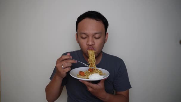 幸せと興奮の表情でインスタントラーメンを食べる若いアジア人男性 — ストック動画