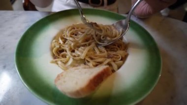Kadınlar çatallı spagetti yiyor.