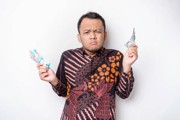 Zmatený Mladý Asijský Muž Sobě Batik Košile Držení Peněz Hotovosti — Stock fotografie