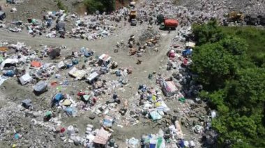 Aerial view of a city dump center full of trash. Herd of cows eating garbage in a landfill. Ecology and health issues.