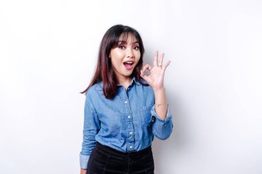 Heyecanlı Asyalı kadın beyaz bir geçmişle izole edilmiş iyi bir el hareketi yapıyor.