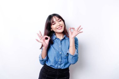 Heyecanlı Asyalı kadın beyaz bir geçmişle izole edilmiş iyi bir el hareketi yapıyor.