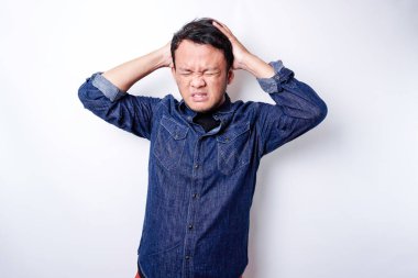 A portrait of an Asian man wearing a blue shirt isolated by white background looks depressed