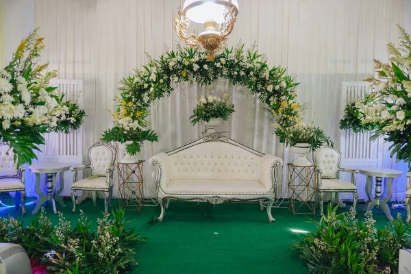 Indoor decoration set up for Javanese wedding with a lot of fresh flowers.