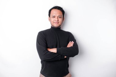 An Asian young confident man posing with crossed arm against a white background.