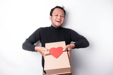 Beautiful young Asian man wearing black shirt holding gift box red heart, Valentine's Day concept.