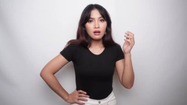 A thoughtful young woman dressed in black shirt while looking aside, isolated by white background