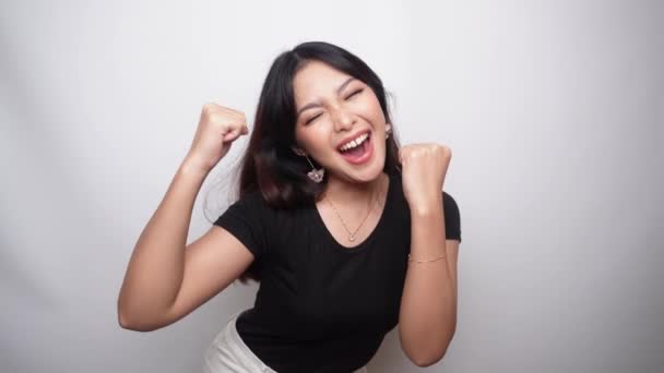 微笑的年轻亚洲女人举起双臂庆祝成功或成就 身穿黑色衬衫的印度尼西亚妇女 — 图库视频影像