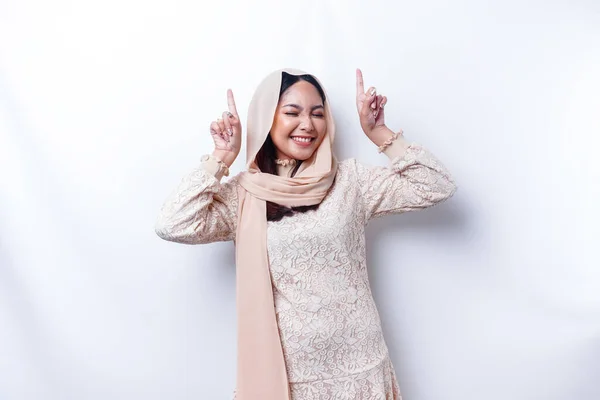 白い背景によって隔離された 彼女の上のコピースペースを指してヒジャーブを身に着けている興奮したアジアのイスラム教徒の女性 — ストック写真