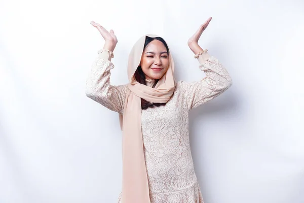 白い背景によって隔離された 彼女の上のコピースペースを指してヒジャーブを身に着けている興奮したアジアのイスラム教徒の女性 — ストック写真
