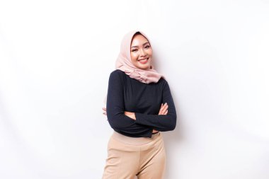 Portrait of a confident smiling Asian Muslim woman wearing hijab standing with arms folded and looking at the camera isolated over white background