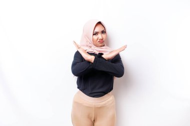 Beautiful Asian Muslim woman wearing a hijab with hand gesture pose rejection or prohibition with copy space