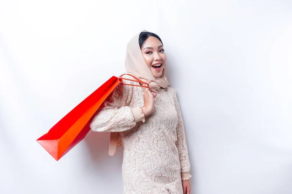 Portrait Asian Muslim woman happy beautiful young standing excited holding a shopping bag, studio shot isolated on white background