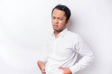 A portrait of insecure Asian fat man is holding the fat on his belly