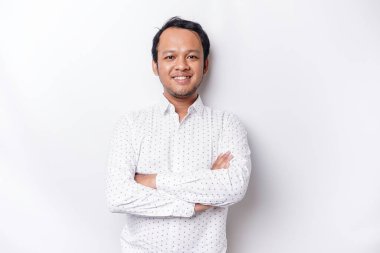 An Asian young confident man posing with crossed arm against a white background.