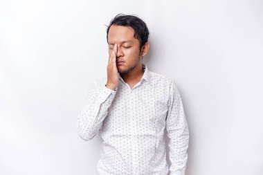 A portrait of an Asian man wearing a white shirt isolated by white background looks depressed