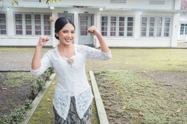 Beyaz kebaya takmış, mutlu ve başarılı bir yüzü olan Endonezyalı genç bir kadın. Kartini Günü Konsepti.