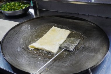 Martabak Telor 'u ya da sıcak yağda omlet martabak' ı kızartmak. Yumurta, et ve baharatla doldurulmuş tuzlu tavada kızartılmış hamur işi. Endonezya 'dan geleneksel yiyecek atıştırmalıkları.