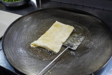 Martabak Telor 'u ya da sıcak yağda omlet martabak' ı kızartmak. Yumurta, et ve baharatla doldurulmuş tuzlu tavada kızartılmış hamur işi. Endonezya 'dan geleneksel yiyecek atıştırmalıkları.