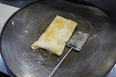 Martabak Telor 'u ya da sıcak yağda omlet martabak' ı kızartmak. Yumurta, et ve baharatla doldurulmuş tuzlu tavada kızartılmış hamur işi. Endonezya 'dan geleneksel yiyecek atıştırmalıkları.