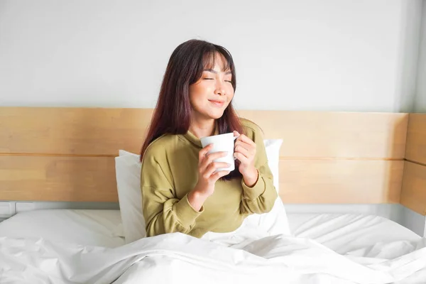 아파트 침대에서 마시고 아름다운 아시아 여성의 — 스톡 사진