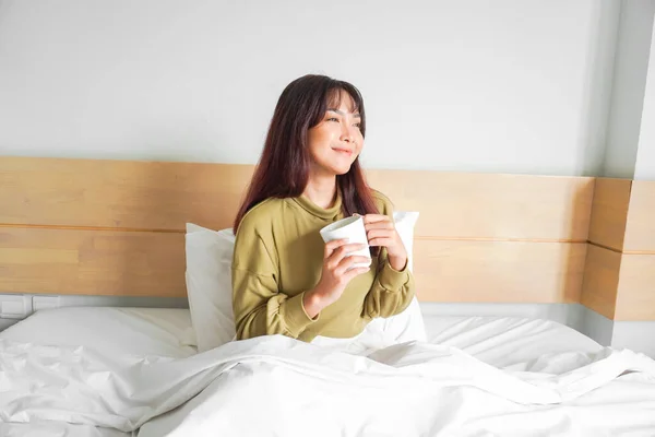 아파트 침대에서 마시고 아름다운 아시아 여성의 — 스톡 사진