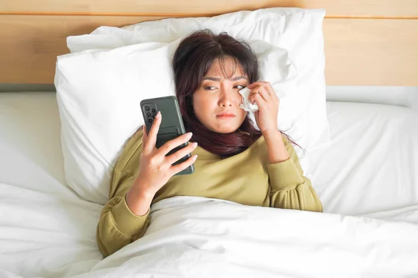 Грустная Молодая Азиатка Плачет Над Телефоном Пока Лежит Кровати — стоковое фото