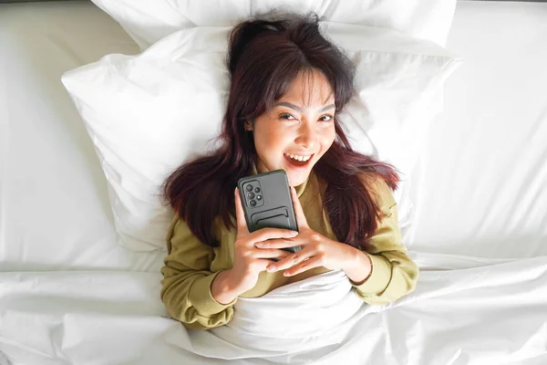 아시아 휴대폰을 침대에 있습니다 — 스톡 사진