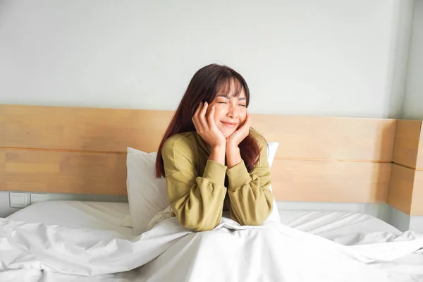 Lykkelig Asiatisk Kvinne Smiler Når Hun Sitter Senga – stockfoto