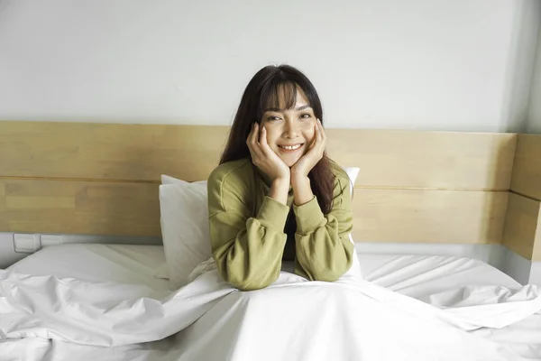 Lykkelig Asiatisk Kvinne Smiler Når Hun Sitter Senga – stockfoto