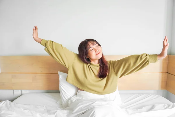 stock image Portrait of beauty happy Asian woman awaking, wake up on the bed (sleep). Young beautiful Asian girl stretching her arms in fresh early morning, relax peaceful morning routine yawn concept banner