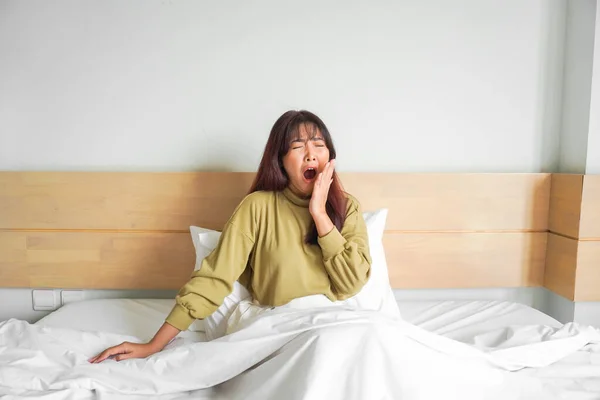 어여쁜 아시아 여성밝은 침실에 그녀의 침대에 스트레칭 — 스톡 사진