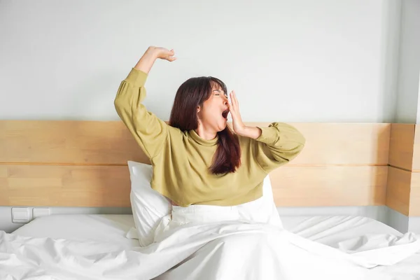 Linda Mujer Asiática Estirándose Bostezando Mientras Está Sentada Cama Dormitorio —  Fotos de Stock