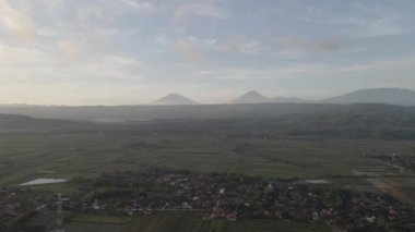 Endonezya 'daki hava dağı, gündoğumu arka planına sahip köy yakınlarında.