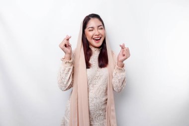 Başörtüsü takan mutlu, genç bir Asyalı kadın romantik şekiller hisseder kalp hareketi şefkatli duygular ifade eder.