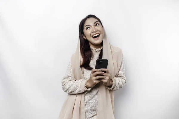 白い背景によって隔離された彼女の携帯電話を保持し スカーフを身に着けている幸せなアジアのイスラム教徒の女性の肖像画 — ストック写真