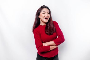 Kırmızı giyinmiş, kollarını kavuşturmuş, beyaz arka planda izole edilmiş kameraya bakan kendinden emin gülümseyen Asyalı kadının portresi.