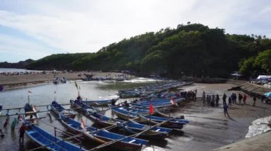 Endonezya Yogyakarta 'daki Baron plajının deniz feneri ve geleneksel tekneli görüntüsü.