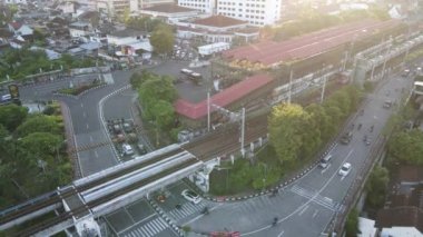 Yolcu treninin Tugu İstasyonu yakınlarındaki tren köprüsünü geçerken hava görüntüsü. Yogyakarta, Endonezya - Ocak 2023. 