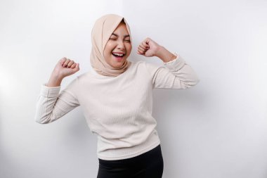 Mutlu bir ifadeyle genç bir Asyalı Müslüman kadın beyaz arka planla izole edilmiş tesettür takıyor.