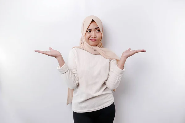 思慮深い若いアジア系イスラム教徒の女性はヒジャーブを身に着けており 白い背景によって隔離された選択との間に混乱している — ストック写真