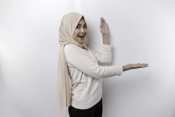 彼女の横にスペースをコピーするために指している間 若いアジアのイスラム教徒の女性笑顔 — ストック写真