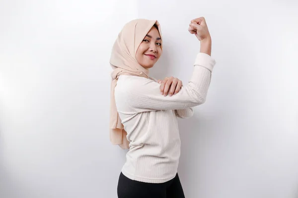 兴奋的亚洲穆斯林妇女 戴着头巾 高傲地举起胳膊和肌肉 表现出强烈的手势 — 图库照片