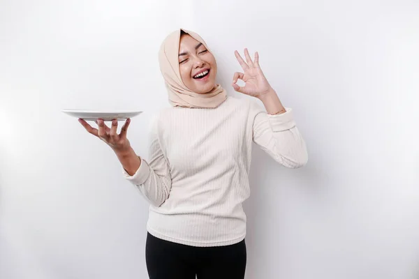 Uśmiechnięta Azjatycka Muzułmanka Pości Głodna Trzyma Wskazuje Talerz — Zdjęcie stockowe