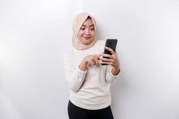 Szczęśliwa Azjatycka Muzułmanka Nosząca Chustę Głowie Trzymająca Telefon Odizolowana Przez — Zdjęcie stockowe