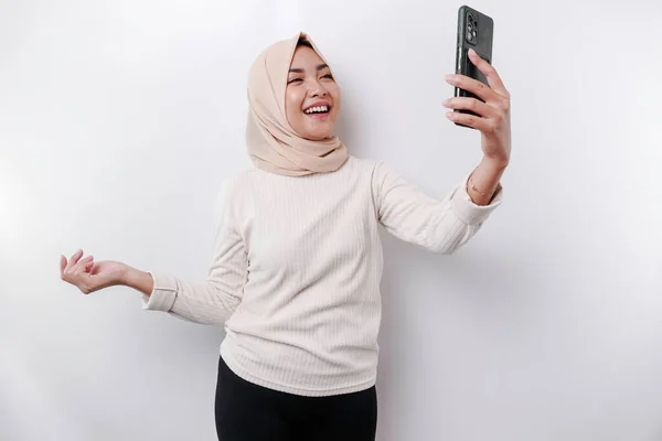 Seorang Wanita Muslim Asia Yang Bahagia Mengenakan Jilbab Memegang Ponselnya — Stok Foto