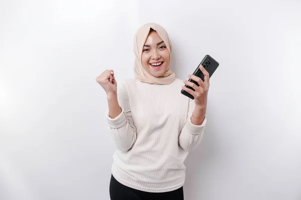 白を基調としたヒジャーブとスマートフォンを持ち 幸せな表情を見せる若いアジア系ムスリム女性 — ストック写真