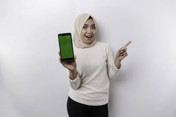 스카프를 흥분한 아시아인 이슬람 핸드폰을 주면서 공간을 가리키고 — 스톡 사진