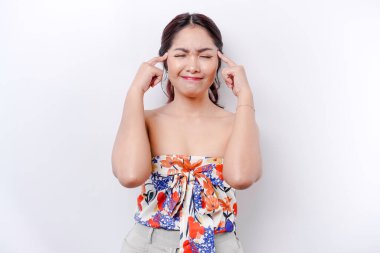 Düşünceli genç bir kadın, beyaz bir arka planda, bir kenara bakıyor.