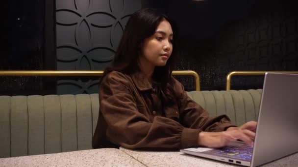 Серьёзная Азиатка Работает Своим Ноутбуком Кафе — стоковое видео